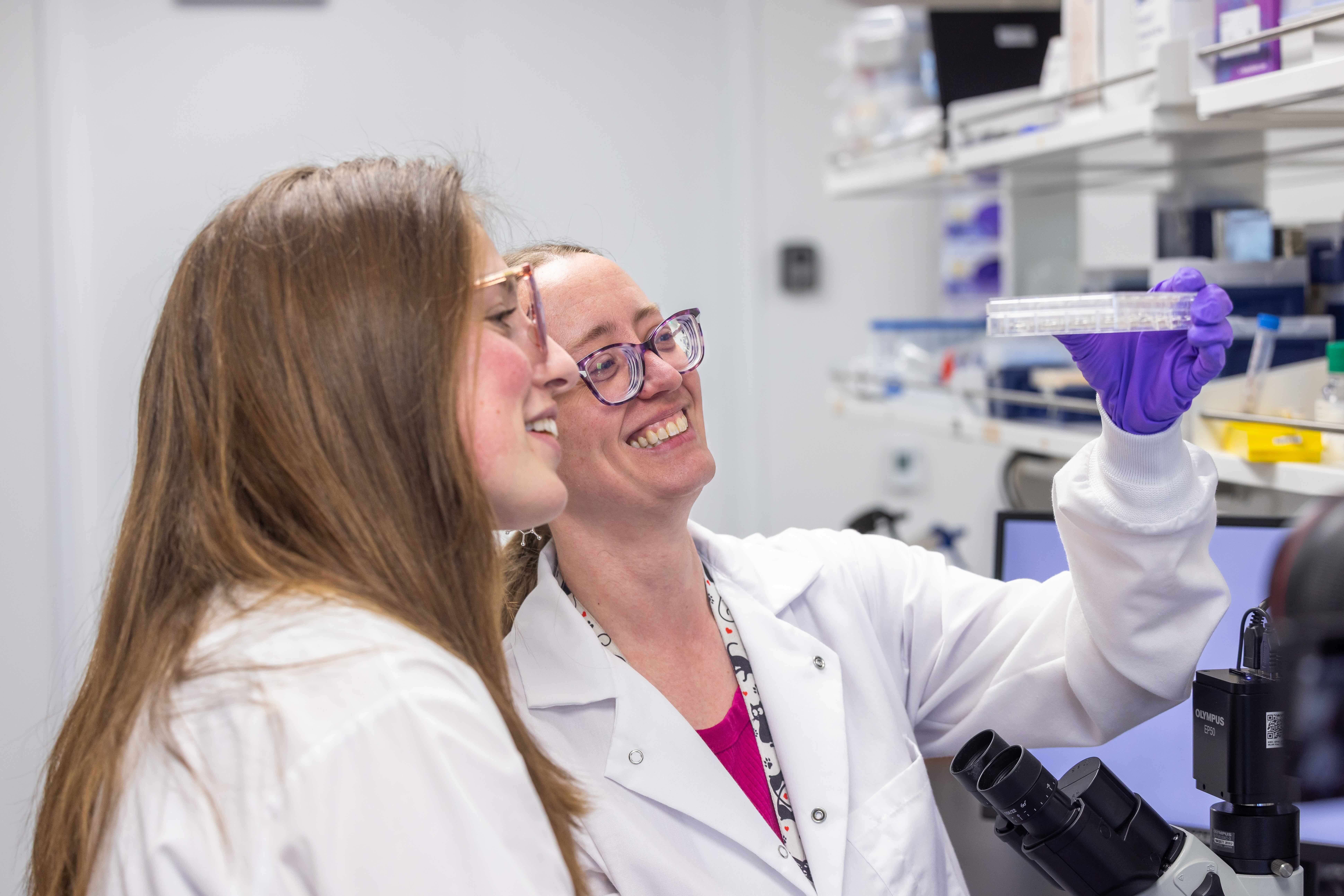 Two womenin Biomedical enineering look at slide