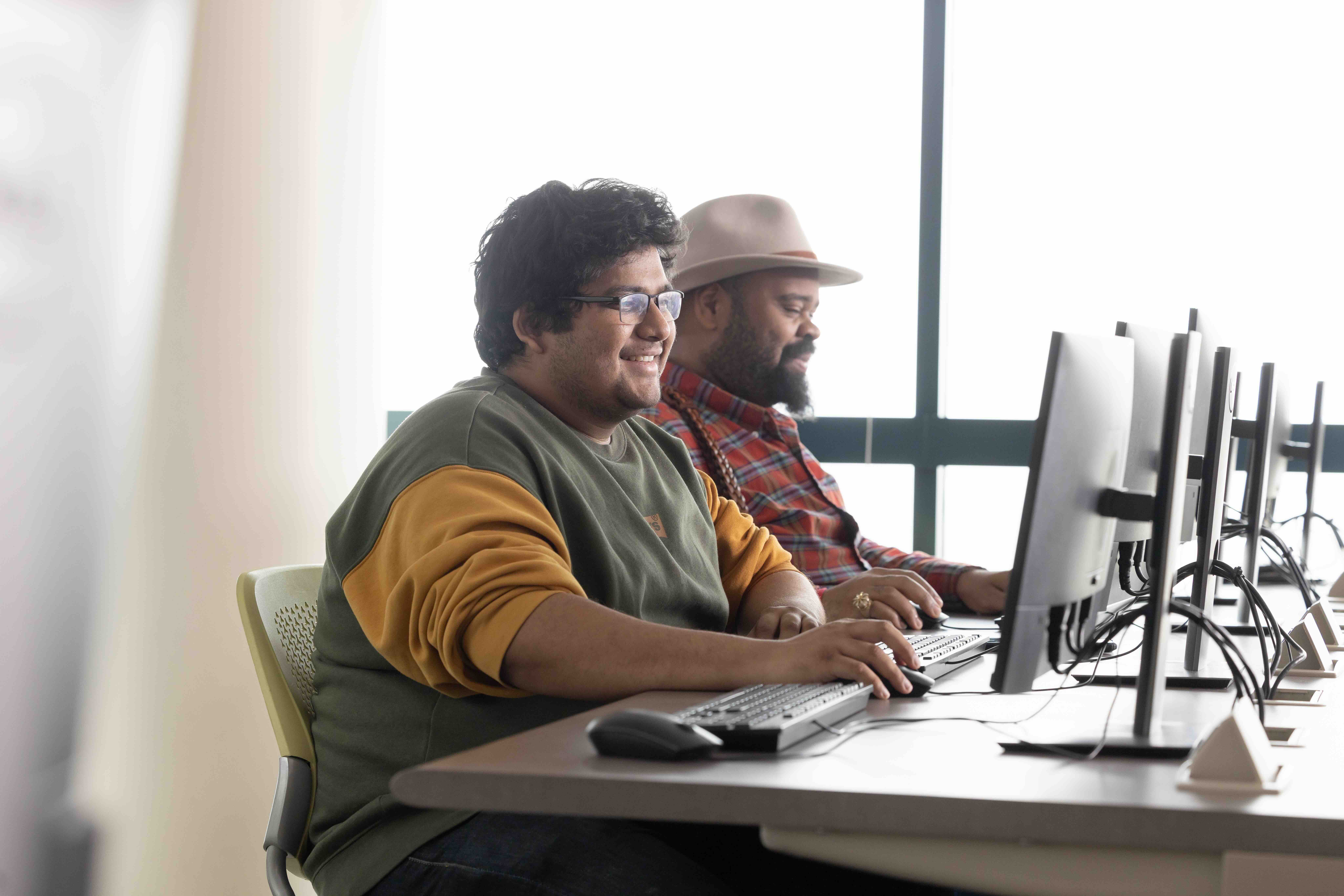 Two Men ositting in front of computer in computer lab