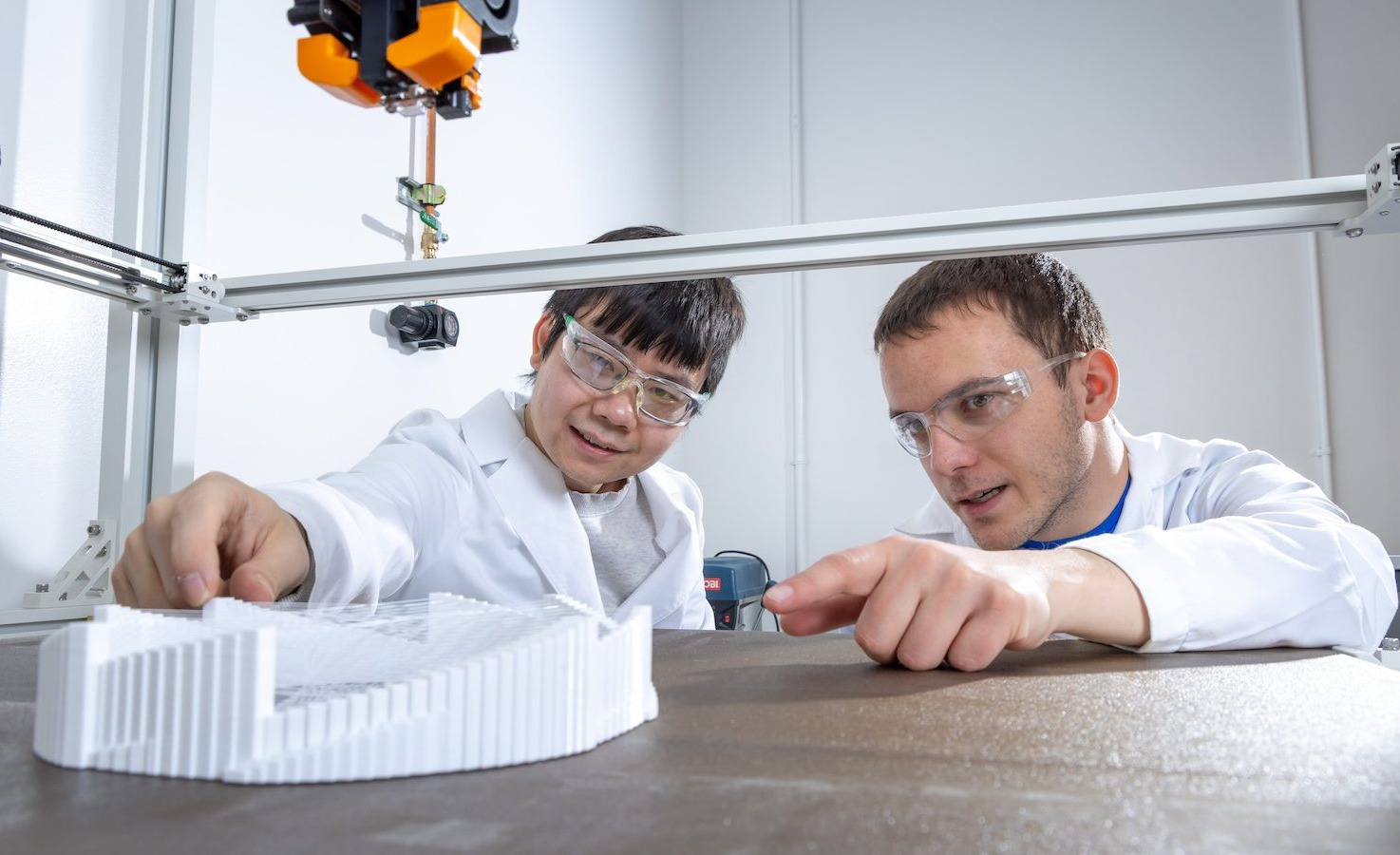 CEDC students Guoying Dong and Nikola Hilderbrand use 3D printing technology in the Additive Manufacturing Lab.